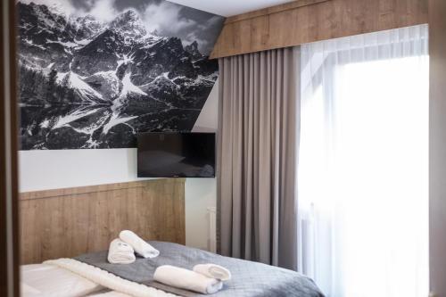 a bedroom with a bed with a mountain picture on the wall at Pokoje u Nasyj Kasi in Poronin
