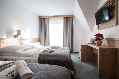 um quarto de hotel com duas camas e uma televisão em Pokoje u Nasyj Kasi em Poronin