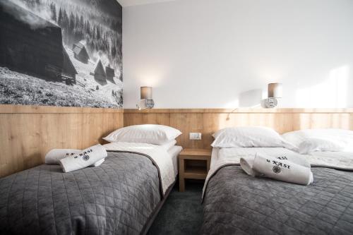 two twin beds in a room with a desk at Pokoje u Nasyj Kasi in Poronin