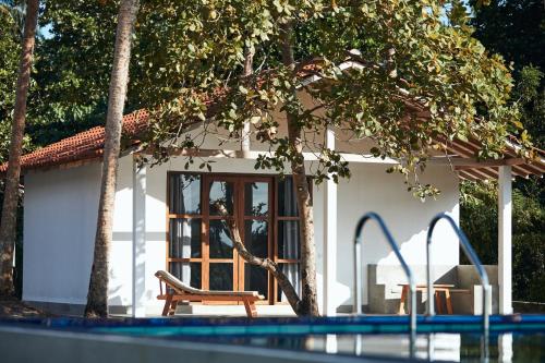 a house with a bench next to a swimming pool at Simply Peace in Tangalle