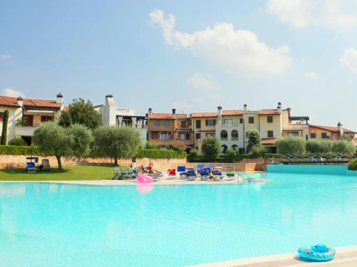 ein großer Pool in einem Resort mit Menschen darin in der Unterkunft Well-kept ground floor apartment near Peschiera in Peschiera del Garda
