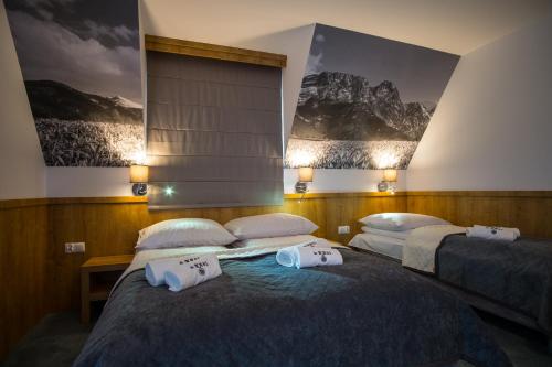 two beds in a room with posters on the wall at Pokoje u Nasyj Kasi in Poronin