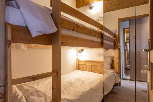 2 Etagenbetten in einem Zimmer mit Spiegel in der Unterkunft Résidence La Forêt du Praz - Courchevel 1850 in Courchevel