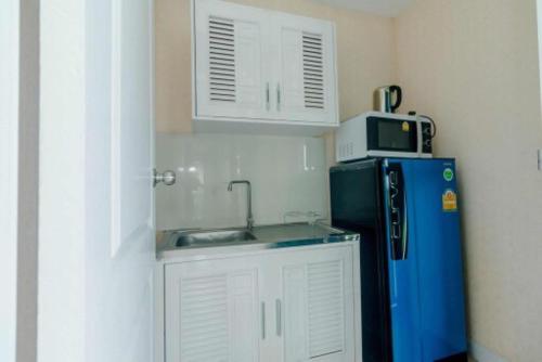 eine Küche mit einer Spüle, einer Mikrowelle und einem Kühlschrank in der Unterkunft Mae On Village Resort in Roi Et