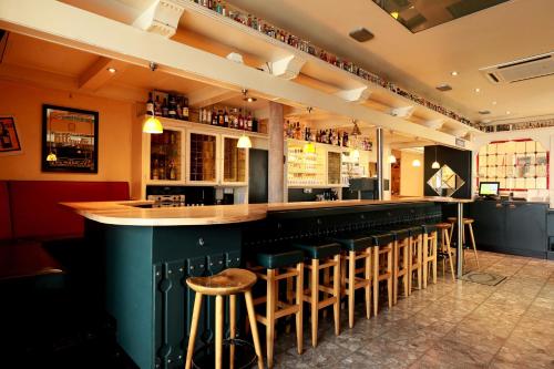 eine Bar mit einer Reihe von Hockern in einem Restaurant in der Unterkunft Mariaweiler Hof in Düren - Eifel