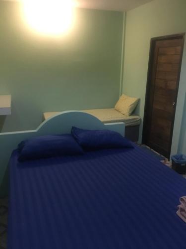 una camera con letto blu e panca di Bangkado Resort a Ratchaburi