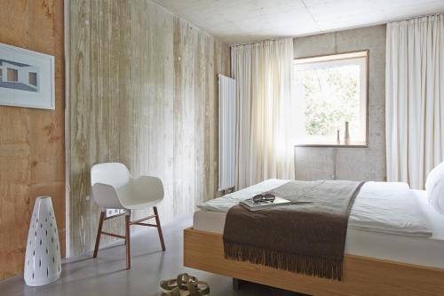 a bedroom with a bed and a chair and a window at ipartment Cologne Muelheim in Cologne