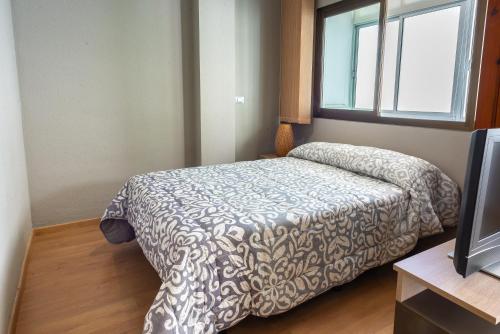 a bedroom with a bed and a window at Central Las Canteras Beach in Las Palmas de Gran Canaria