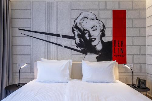 uma cama com uma pintura de um presidente cabeça em uma parede em Platforma Design Hotel em Tbilisi
