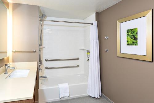 a bathroom with a shower and a white tub at Staybridge Suites - Fort Lauderdale Airport - West, an IHG Hotel in Davie