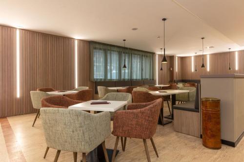 a restaurant with tables and chairs in a room at Hotel Miletto in San Massimo