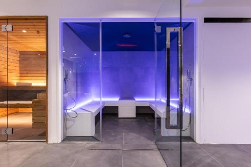 a bathroom with a shower with purple lighting at Hotel Miletto in San Massimo