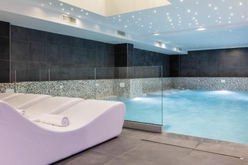 a large bath tub in a room with a swimming pool at Hotel Miletto in San Massimo