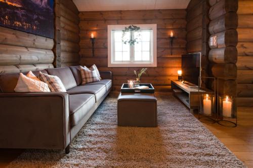 un soggiorno con divano e TV di Strandafjellet Mountain Lodge a Stranda