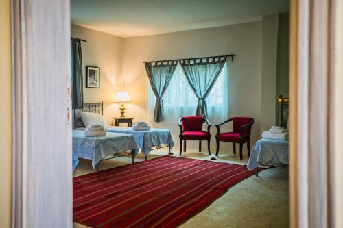 a room with two tables and two chairs and a bed at Beit Al Baraka in Um Qeis