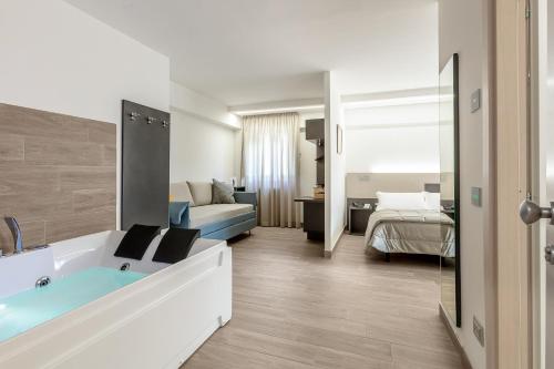 Hotel Miletto في سان ماسيمو: حمام مع حوض استحمام وغرفة نوم