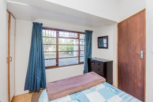 a bedroom with a bed and a window at Seas the Day in Arniston