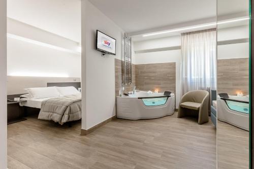 a bedroom with a bed and a bath tub and a sink at Hotel Miletto in San Massimo