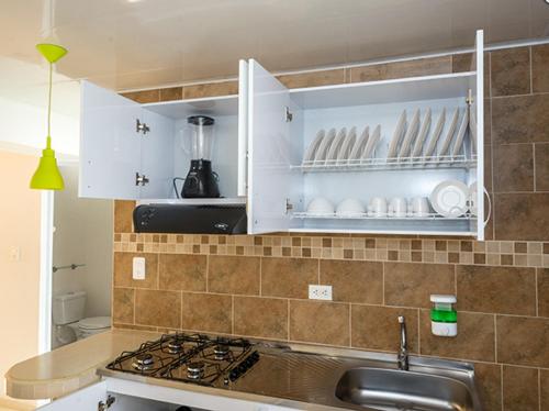uma cozinha com um lavatório e uma bancada em ApartaHotel Luxury em Paipa