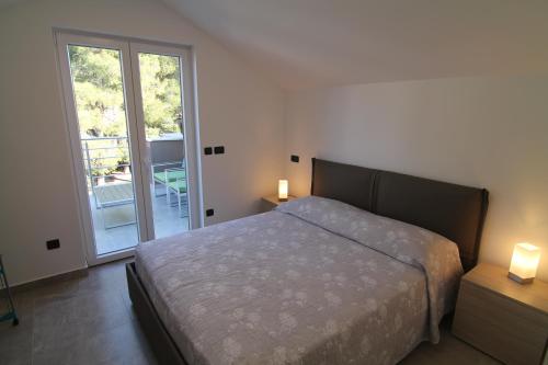 a bedroom with a bed and a sliding glass door at SeaHouse 114 in Mali Lošinj