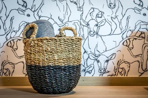 a basket sitting on a table in front of a drawing of cows at Gasthaus Brünig Kulm in Brunig