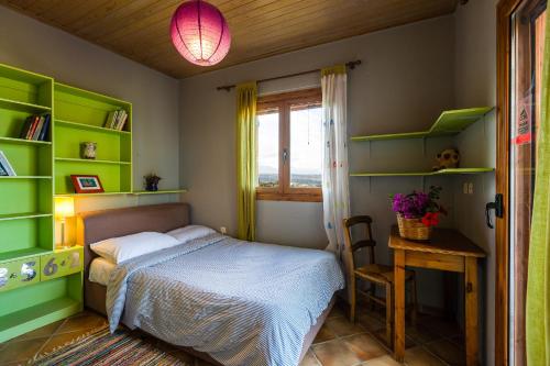 ein Schlafzimmer mit grünen Regalen, einem Bett und einem Tisch in der Unterkunft Diktamos Villas in Atsipopoulo