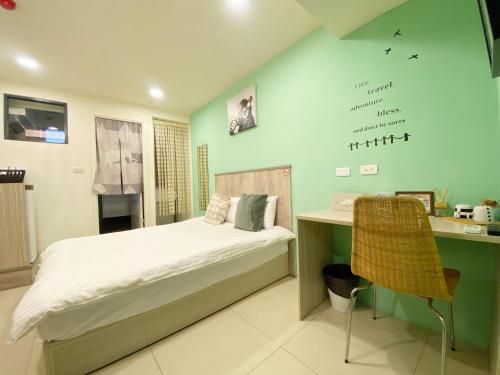 a bedroom with a bed and a desk with a writing on the wall at Day Day Fengjia in Taichung