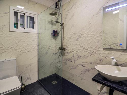 a bathroom with a glass shower and a sink at Perfect Apartment in Puerto de la Cruz