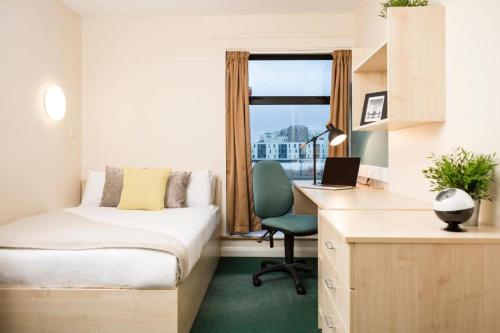 a bedroom with a bed and a desk with a laptop at Bonington Student Village (Campus Accommodation) in Sutton Bonington