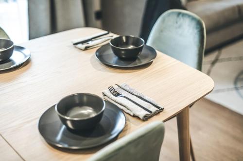 a wooden table with three black cups on it at Oskar Apartments in Neustift im Stubaital