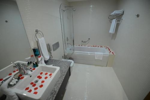 a bathroom with a sink and a bath tub at Arsan Otel in Kahramanmaras