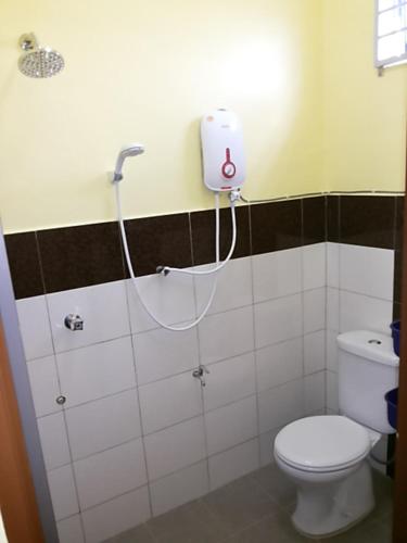 a bathroom with a white toilet and a shower at Chalet Purnama in Alor Setar