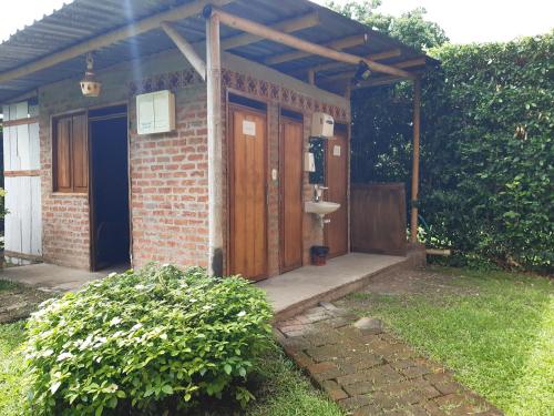 a brick house with a wooden door and a sink at Finca el Morichal in Buga