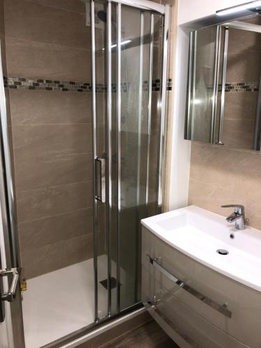 W łazience znajduje się prysznic i umywalka. w obiekcie Charmante maison cœur de ville La Gare des vacances w mieście Deauville