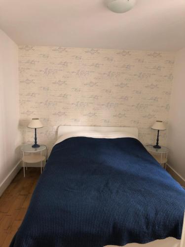 1 dormitorio con 1 cama azul y 2 lámparas en Charmante maison cœur de ville La Gare des vacances en Deauville