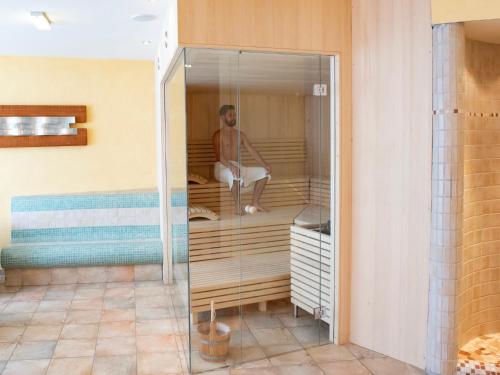 a woman sitting in a glass enclosure in a room at Glanzer Homes Hochsölden in Sölden