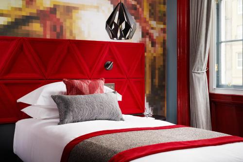 a red bed with a red headboard in a room at Malmaison Edinburgh City in Edinburgh