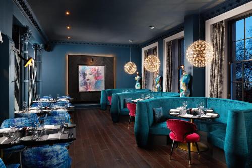 a dining room with blue chairs and tables and chandeliers at Malmaison Edinburgh City in Edinburgh