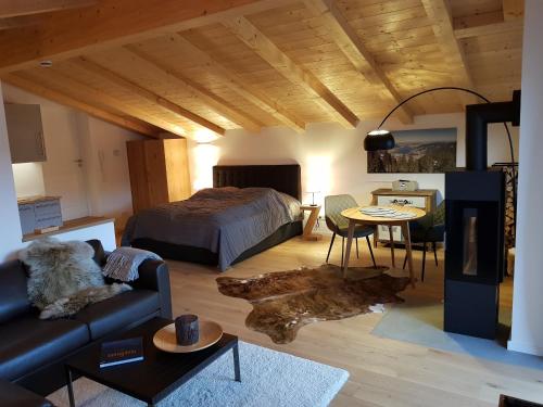 um quarto com uma cama, um sofá e uma mesa em Bodenschneid Suiten Neureuthblick em Kreuth