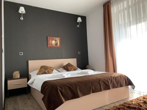 a bedroom with a large bed with a black wall at TIAM Apartment Poiana Brașov D117, 3 rooms, 3 terraces, 3 bathrooms in Poiana Brasov