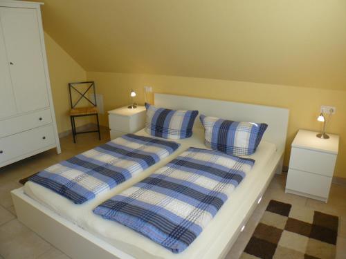 a bedroom with two beds with blue and white pillows at Apartments Sonnendeck in Warnemünde