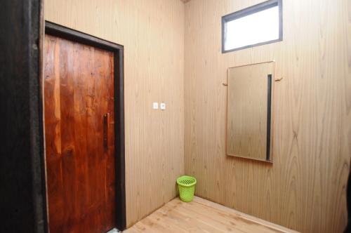 a room with a wooden door and a mirror at Sunari Beach Resort 2 in Selayar