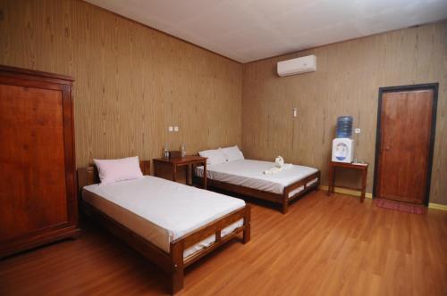 a room with two beds and a tv in it at Sunari Beach Resort 2 in Selayar
