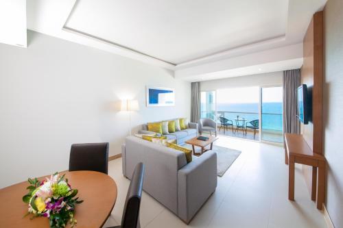 a living room with a couch and a table at Ramada by Wyndham Beach Hotel Ajman in Ajman 