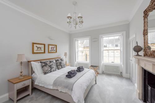 een witte slaapkamer met een bed en een open haard bij Brunswick Place in Bath