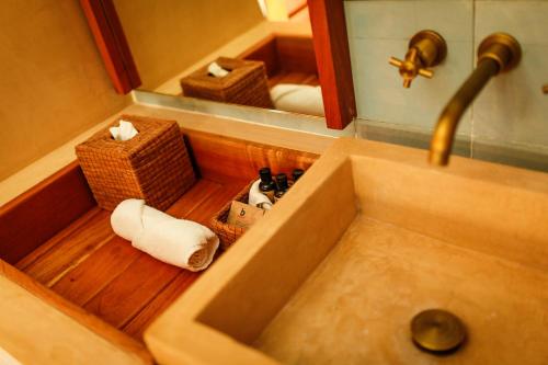 a sink in a bathroom with a mirror and towels at Hotel Carolina Bacalar in Bacalar