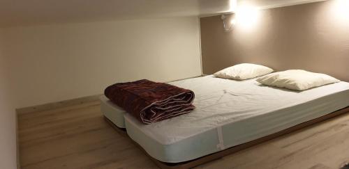 a bed with two pillows on it in a room at Triplex E12 Résidence Les Lauzes - Les Menuires - Croisette in Les Menuires