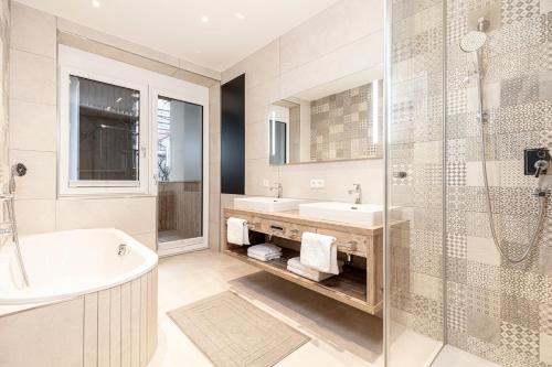 y baño con bañera, lavamanos y ducha. en Center-Apartment - Große Wohnung im Stadtzentrum in perfekter Lage en Innsbruck