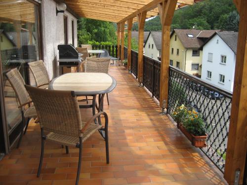 a patio with chairs and a table on a balcony at Ferienwohnung Schehl in Erlenbach