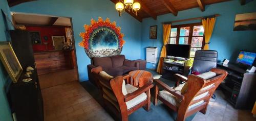 a living room with a couch and two chairs at La Estacion Hostel in Lago Puelo